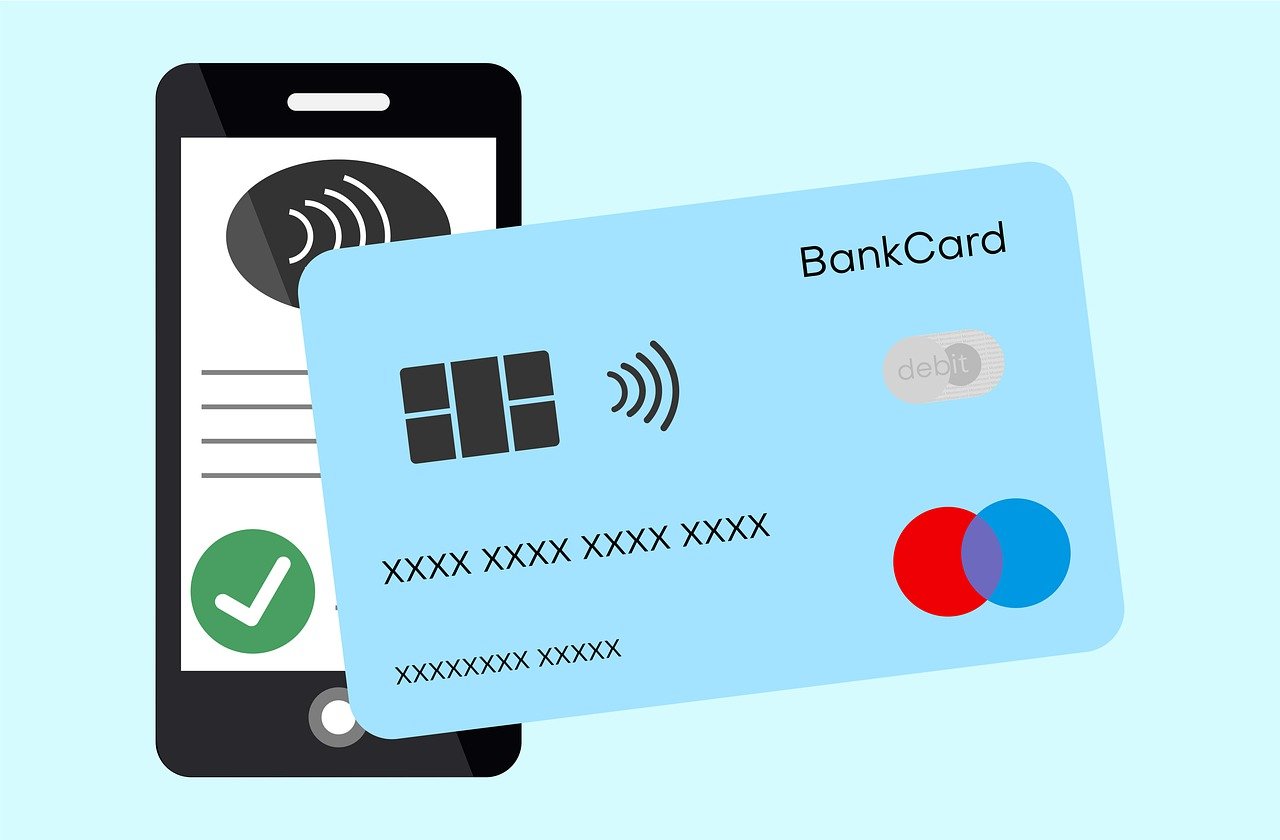 Die Grafik zeigt im Vordergrung eine Hellblaue Kreditkarte und im Hintergrund ein mobiles Telefeon, das eine mobile banking app gestartet hat.