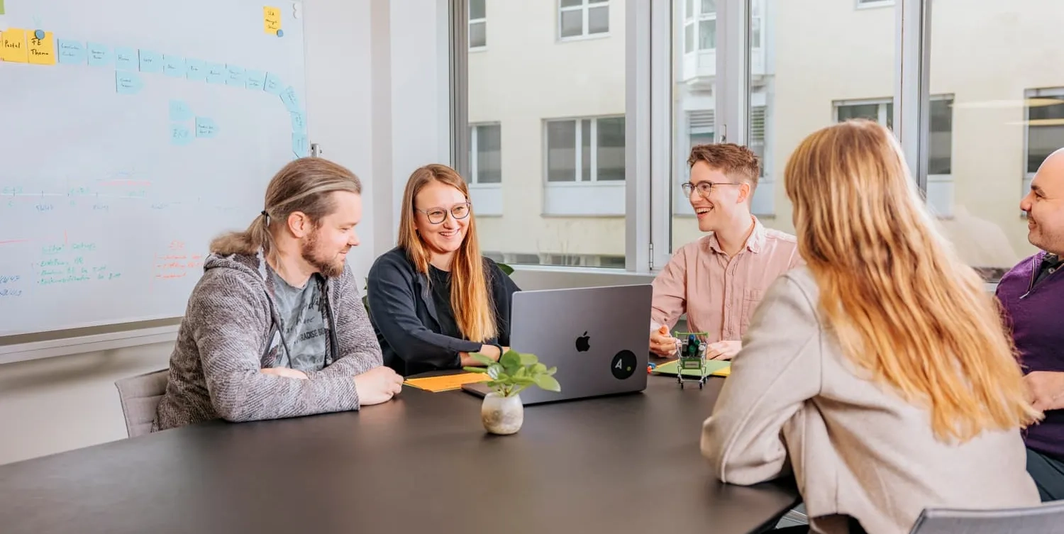 Gruppe von Menschen sitzen an einem Pult